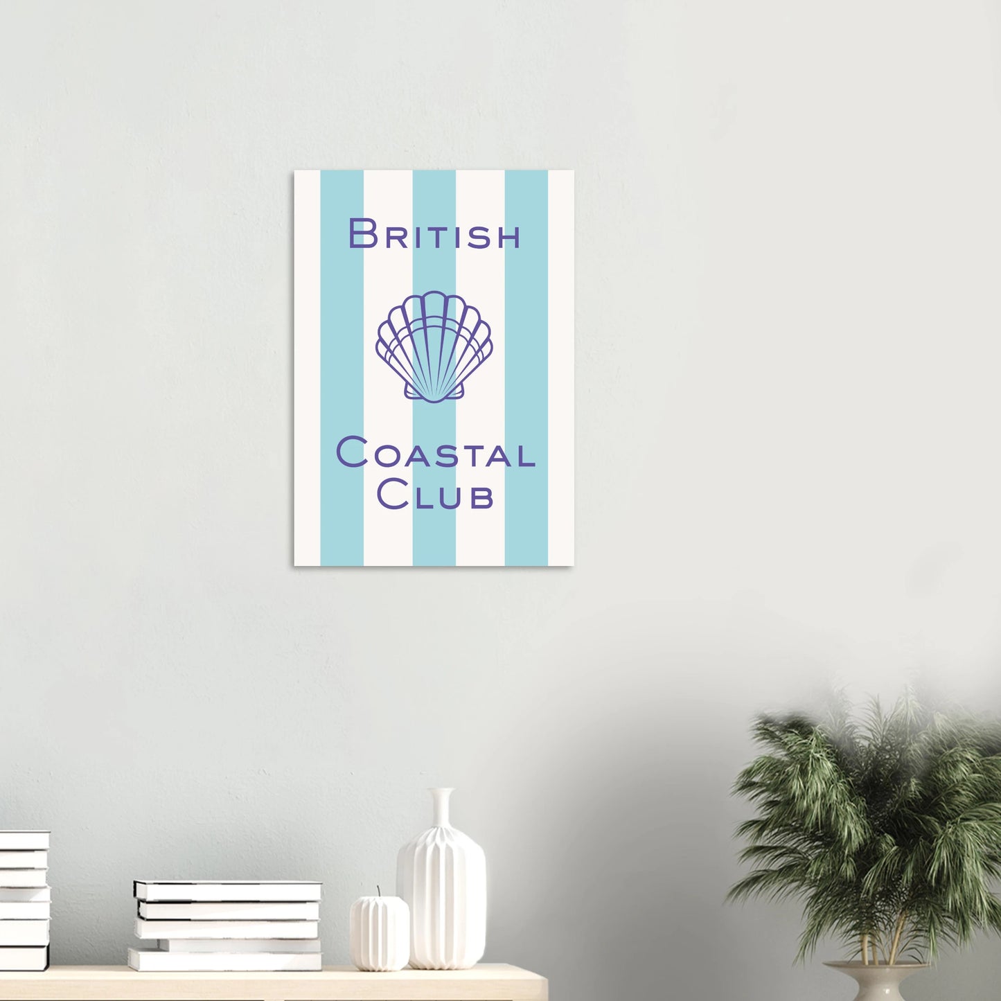Aesthetic coastal art print titled British Coastal Club featuring a purple geometric scallop shell illustration and matching thin border over a light blue and white vertically striped background.
