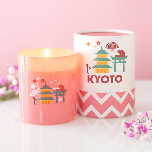 Pink frosted glass candle with Kyoto pagoda and crane illustrations, sitting next to a matching pink and white chevron gift tube