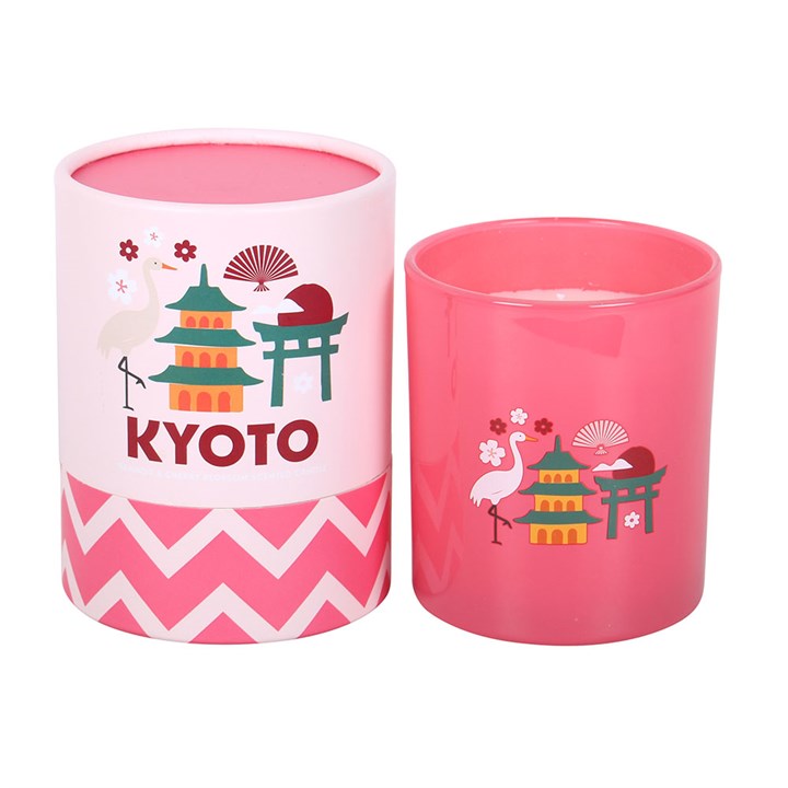 Pink frosted glass candle with Kyoto pagoda and crane illustrations, sitting next to a matching pink and white chevron gift tube on a white background