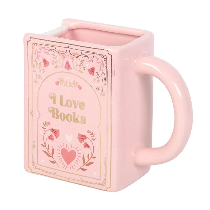 Pastel pink rectangular ceramic mug shaped like a hardcover book with gold floral illustrations and the words 'I Love Books' printed on the cover showing handle on a white background