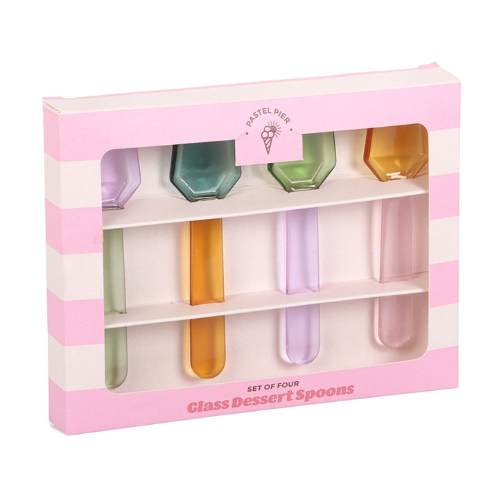 Four translucent glass dessert spoons in pastel lilac, blue, green, yellow in a pink and white striped box on a white background