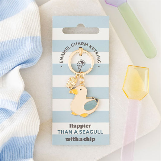 Enamel seagull keyring with a small gold chip charm on a blue and white striped card that says 'Happier than a seagull with a chip'.