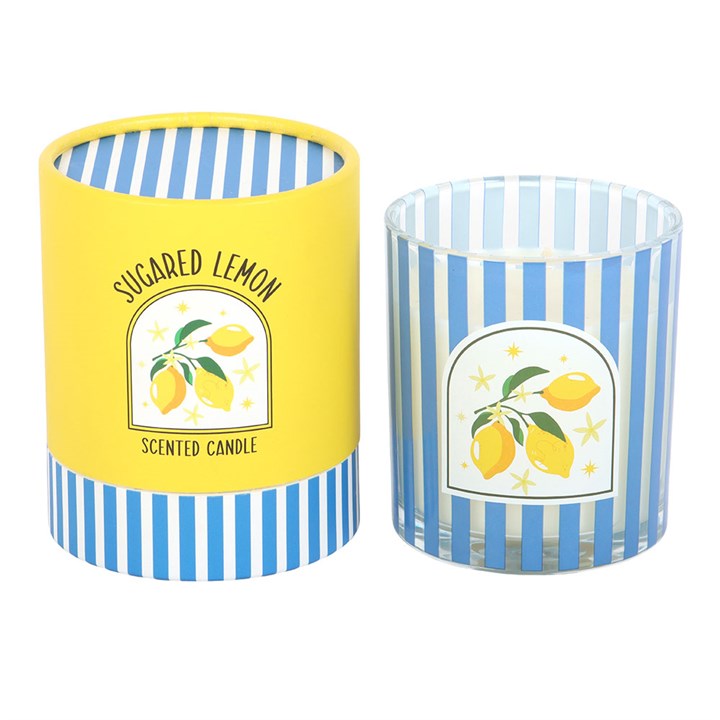Blue and white vertical striped glass candle with a lemon illustration, sitting next to a matching yellow and blue striped gift tube on a white background