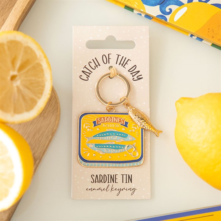 Vibrant yellow and blue enamel keyring shaped like a sardine tin with a small dangling gold fish charm.