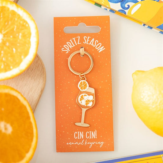 Gold-tone enamel keyring featuring a vibrant orange spritz cocktail glass with an orange slice 